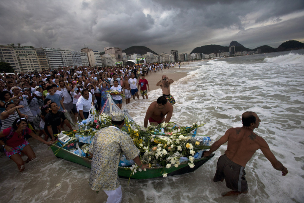 Brazilian citizen on a coast of Rio de Janeiro are also offering white flowers and gifts Sea